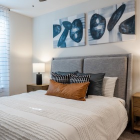Find your perfect fit at Madison Century Farms Modern bedroom with a gray upholstered bed, white bedding, and matching nightstands with lamps.