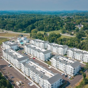 Settle into comfort at Madison Century Farms An aerial photo of large white buildings, with blue skies and rolling hills in the background.
